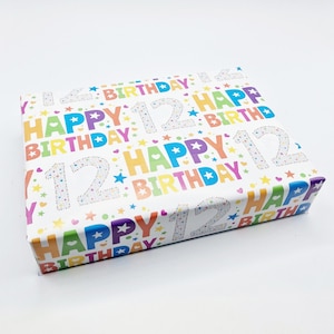 Puede incluir: Papel de regalo blanco con un patrón repetitivo de colores de las palabras "Feliz cumpleaños" y el número "12" con estrellas y corazones.