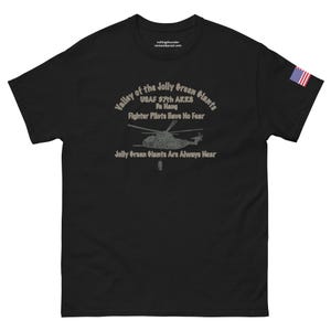 May include: Black t-shirt with a graphic of a helicopter and the text "Valley of the Jolly Green Giants USAF 57th ARRS Pa Hang Fighter Pilots Have No Fear Jolly Green Giants Are Always Near".