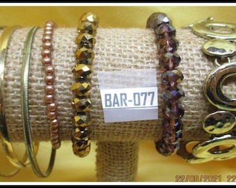 7 pulseras variadas, vintage y modernas, en su mayoría bandas doradas, atrevidas