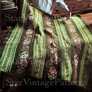 Może przedstawiać: Zielony i brązowy pled szydełkowy z kwiatowym wzorem. Pled jest złożony na pół i trzymany przez osobę.