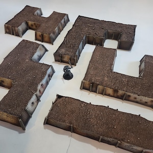 May include: Five brown and grey cardboard trenches with corrugated metal siding. The trenches are arranged in a zig-zag pattern on a white surface.