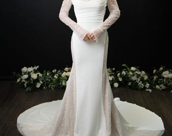 May include: A white off-the-shoulder wedding gown with long, sheer sleeves adorned with sparkling embellishments. The dress features a fitted bodice and a flowing skirt with a train. The background is black with floral decorations.