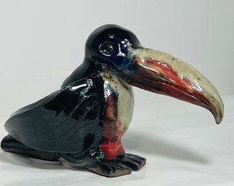 Figura in ceramica con tucano che fischia