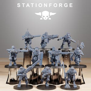Könnte beinhalten: Eine Sammlung grauer Miniaturfiguren von Soldaten, die jeweils eine Waffe oder ein Werkzeug halten. Die Figuren stehen auf schwarzen, kreisförmigen Sockeln. Das Wort "STATIONFORGE" und ein Totenkopf-Logo sind im Hintergrund zu sehen.
