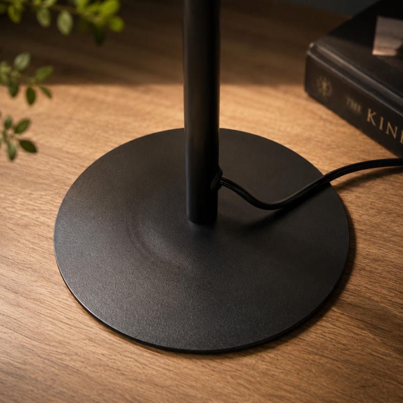 Black metal base detail of music themed bedside table lamp