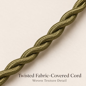 Close-up of an olive-green fabric-covered pendant cord, showing two strands twisted together and the fine woven texture against a cream background.