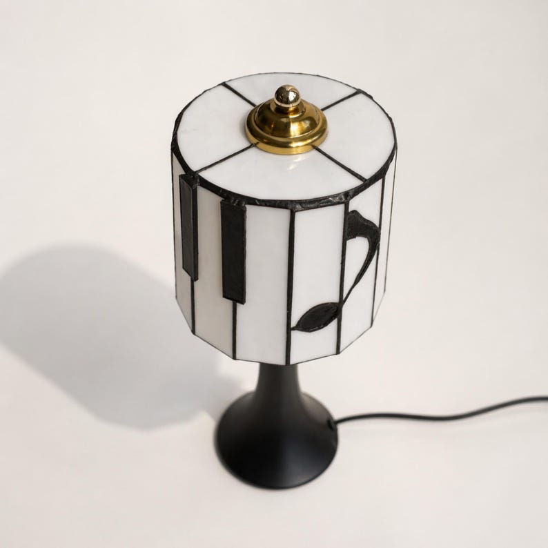 Top view of the piano stained glass lamp shade with brass finial and white glass panels.