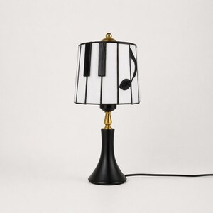 Comparison of the piano stained glass table lamp turned on and off, showing warm glow and natural white glass color.