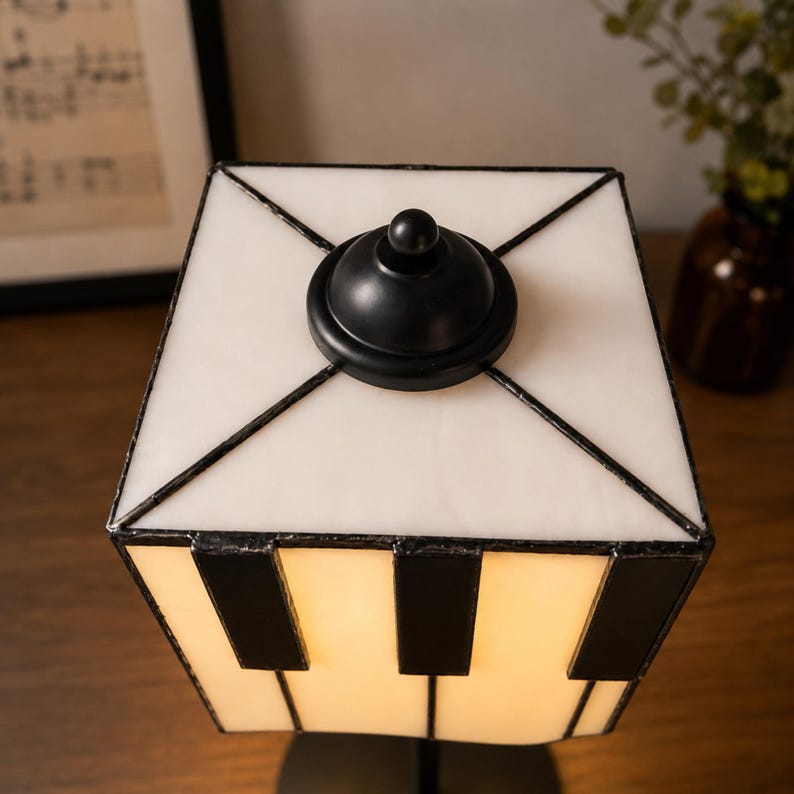 Top detail of square stained glass lampshade with black metal finial