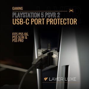 May include: A black USB-C port protector for PlayStation 5 PSVR 2, with the text "GAMING PLAYSTATION 5 PSVR 2 USB-C PORT PROTECTOR". The protector fits PS5 OG, PS5 Slim & PS5 Pro consoles. The Layer Luxe logo is at the bottom.