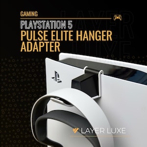 May include: A black and white Pulse Elite Hanger Adapter for the Playstation 5 console. The adapter is designed to hold a headset. The image includes the text "GAMING", "PLAYSTATION 5", "PULSE ELITE HANGER ADAPTER", and "LAYER LUXE".