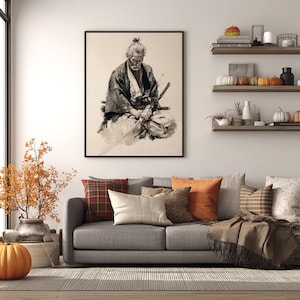 May include: A framed black and white print of a samurai, seated and holding a sword. The artwork hangs above a gray sofa with decorative pillows. The room is decorated with fall-themed accents, including pumpkins and autumn foliage.