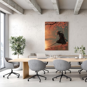 Peut inclure: Impression sur toile encadrée représentant un samouraï en tenue noire, agenouillé avec une épée. L'œuvre présente un fond de coucher de soleil avec des pétales de fleurs de cerisier. L'impression est dans un bureau moderne.