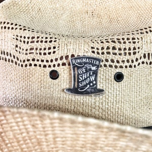 May include: A straw cowboy hat with a black and white patch that reads "Ringmaster of the Shit Show".