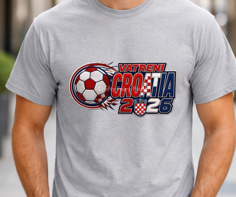 May include: A light gray t-shirt featuring a soccer ball and the text "VATRENI CROATIA 2026" in red, white, and blue. The design includes the Croatian coat of arms and a stylized flame effect.