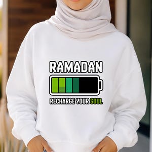 Unisex Ramadan “Recharge Your Soul” graphic shirt featuring a modern battery design symbolizing spiritual renewal. Handmade in the USA using durable DTF transfer. Available as t-shirt, long sleeve, or sweatshirt.