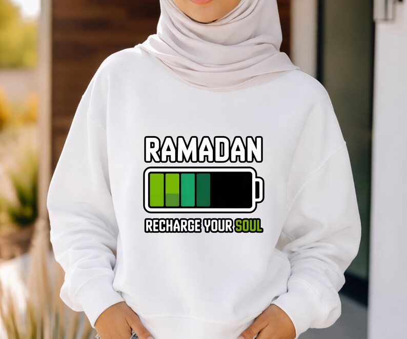 Unisex Ramadan “Recharge Your Soul” graphic shirt featuring a modern battery design symbolizing spiritual renewal. Handmade in the USA using durable DTF transfer. Available as t-shirt, long sleeve, or sweatshirt.