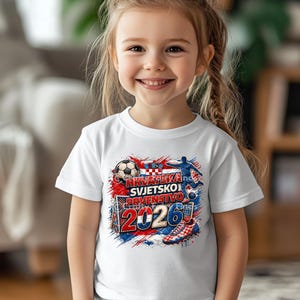 May include: A white t-shirt featuring a colorful graphic design with the text "HRVATSKA SVJETSKO PRVENSTVO 2026". The design includes a soccer ball, a soccer player, and the Croatian flag colors.
