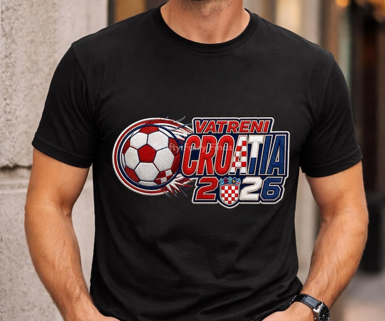 May include: Black t-shirt featuring a soccer ball design with the text "VATRENI CROATIA 2026". The design includes the Croatian flag colors of red, white, and blue. The soccer ball is red and white.