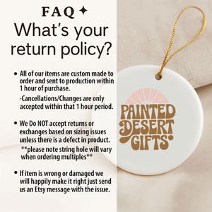 May include: A white ceramic ornament with a gold string for hanging. The ornament features the text "PAINTED DESERT GIFTS" in brown and a pink sun design. The text "FAQ What's your return policy?" is also visible.
