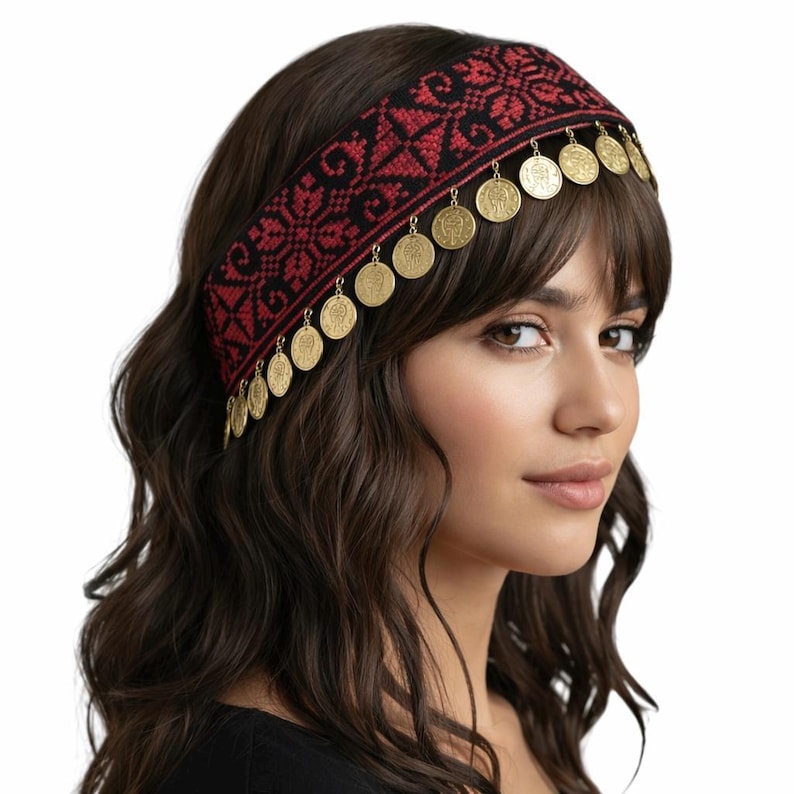 Puede incluir: Una diadema ancha con un patr&oacute;n geom&eacute;trico tejido en negro y rojo. El borde inferior de la banda est&aacute; decorado con una hilera de peque&ntilde;as monedas circulares de metal dorado que cuelgan de la tela, creando un efecto colgante sobre la frente.