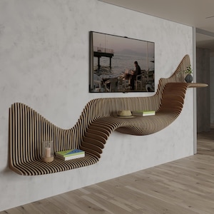 May include: A modern, wavy wooden wall shelf with a built-in TV. The shelf is made of vertical wooden slats and has a unique, flowing design. It holds books, a candle, and a vase. The TV displays a scenic image.