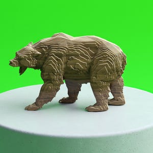May include: A brown wooden bear sculpture with a layered design, standing on a white surface against a bright green background. The bear is depicted in a walking pose, with its mouth open.