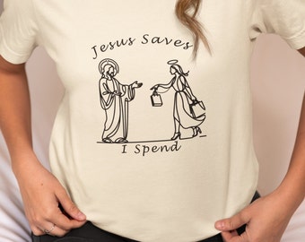 May include: A white t-shirt with a black line drawing of Jesus and an angel. The text "Jesus Saves I Spend" is printed on the shirt.