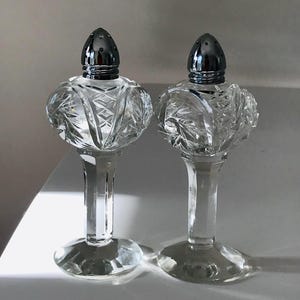 Elegant pressed glass footed salt and pepper shakers
