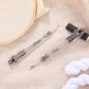 May include: Two silver threader tools with ornate handles and personalized names "Elaine" and "Suzee".