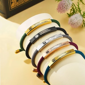 May include: Five different medical alert bracelets with engraved information. The bracelets are made of metal and have a variety of coloured cords. The engraved information includes medical conditions, allergies, and emergency contact information.