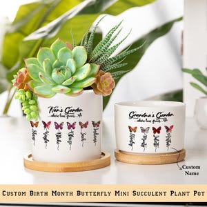 May include: Two white ceramic succulent pots with a butterfly design and the text "Nan's Garden...where love grows..." and "Grandma's Garden...where love grows..."  Each pot has a wooden base and features a different set of butterflies representing birth months.