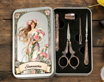 May include: A rectangular metal sewing kit case featuring an illustration of a woman holding flowers with the name Samantha printed on a banner. The open case contains a thimble, scissors, a needle case, and an awl set in a black foam insert.