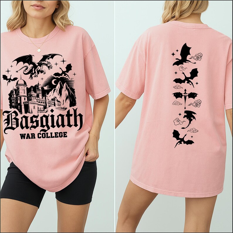 May include: A light pink t-shirt featuring a black graphic on the front with a dragon, castle, and the text "Basgiath War College." The back of the shirt has a vertical design of dragons and clouds.