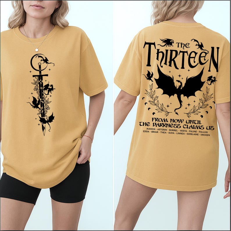 May include: Mustard yellow t-shirt with a black graphic on the front featuring a sword, flowers, and bats. The back of the shirt has the text "The Thirteen" above a dragon graphic and the phrase "From Now Until The Darkness Claims Us."