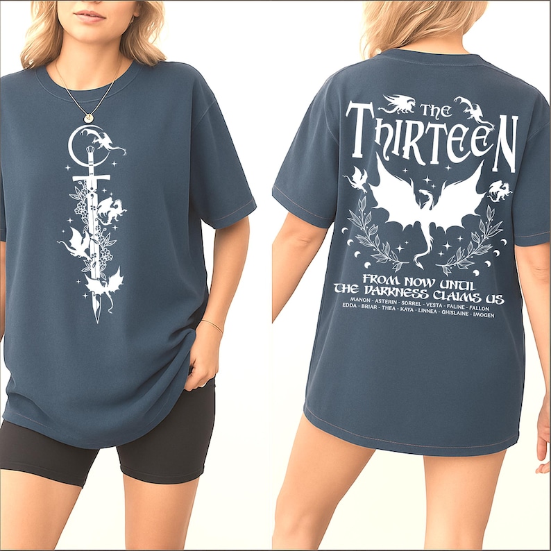 May include: Dark blue t-shirt with a white graphic on the front featuring a sword, flowers, and winged creatures. The back of the shirt displays the text "The Thirteen" above a winged creature design and the phrase "From Now Until The Darkness Claims Us."