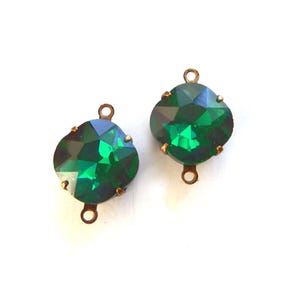 May include: Two emerald green crystal charms with antique gold-tone metal settings. Each charm has two loops for attaching to jewelry.