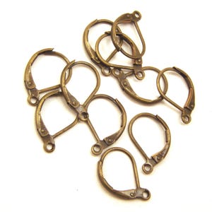 May include: A group of ten antique brass earring hooks. The hooks are made of metal and have a teardrop shape. They are perfect for making your own earrings.
