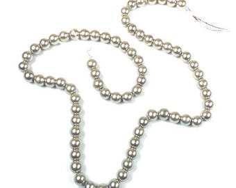 May include: A necklace and bracelet set featuring lustrous, silvery-gray beads. The necklace is long and flowing, while the bracelet is a smaller, matching strand. The beads have a smooth, spherical shape, creating a classic and elegant look.
