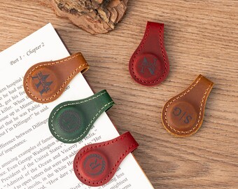 May include: Four leather book markers with magnetic closures. Each marker has a different color and a monogrammed initial on the front. The initials are "K", "S/S", "R", and "M/W".