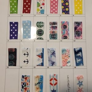 May include: A grid of twenty-three rectangular ribbon swatches arranged in four rows, each labeled with a number. The ribbons feature various patterns including polka dots, nautical themes, coffee logos, and colorful abstract designs on textured fabric.