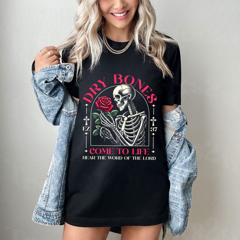May include: Black t-shirt with a graphic of a skeleton holding a red rose. The text "DRY BONES COME TO LIFE HEAR THE WORD OF THE LORD" is printed on the shirt.