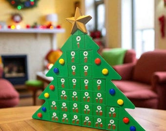 Könnte beinhalten: Ein grüner Adventskalender in Form eines Weihnachtsbaums aus Holz mit einem goldenen Stern. Der Kalender hat 24 nummerierte Türen, jede mit einem kleinen Bild. Bunte runde Ornamente schmücken den Baum.