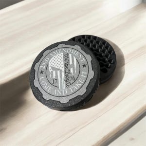 Peut inclure: Deux dessous de verre ronds noirs. L'un présente un motif argenté avec un crâne, un drapeau américain et le texte "2nd Amendment Come and Take It 1776". L'autre a un motif quadrillé.