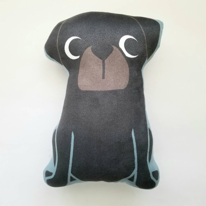 Puede incluir: Un juguete de peluche de perro negro con ojos blancos y una nariz marr&oacute;n. El perro est&aacute; sentado con las patas metidas debajo del cuerpo.