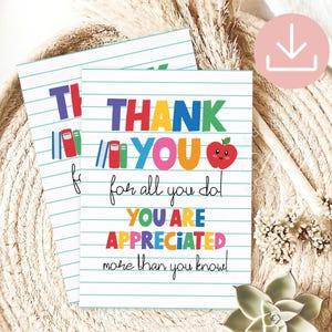 May include: Two white cards with blue lined paper design. The cards have the words "THANK YOU" in colorful letters, with an apple graphic. The text "for all you do! YOU ARE APPRECIATED more than you know!" is also on the cards.