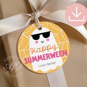 May include: A round gift tag with a cartoon ghost wearing sunglasses, set against a yellow spiderweb design. The tag reads "Happy SUMMERWEEN" in orange and pink, with "Love, Hannah" below. The tag is tied to a wrapped gift with a cream ribbon.