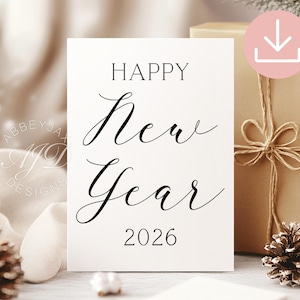 May include: A white card with the words "HAPPY New Year 2026" in elegant black script. The card is propped up in front of a wrapped gift box tied with twine, and decorated with pinecones. A pink download icon is in the upper right corner.