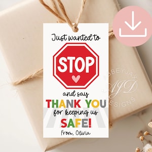 Könnte beinhalten: Ein rechteckiges weißes Geschenkanhänger-Schild mit einem roten achteckigen Stoppschild-Motiv und einem kleinen rosa Herz. Der Text lautet: Just wanted to STOP and say THANK YOU for keeping us SAFE! From, Olivia. Befestigt mit einer braunen Kordel.