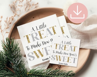 Peut inclure: Cartes carrées blanches avec le texte "A Little TREAT To Make New Year's SWEET" en lettres argentées et dorées à paillettes. Les cartes sont disposées sur un plateau en bois avec de la verdure.